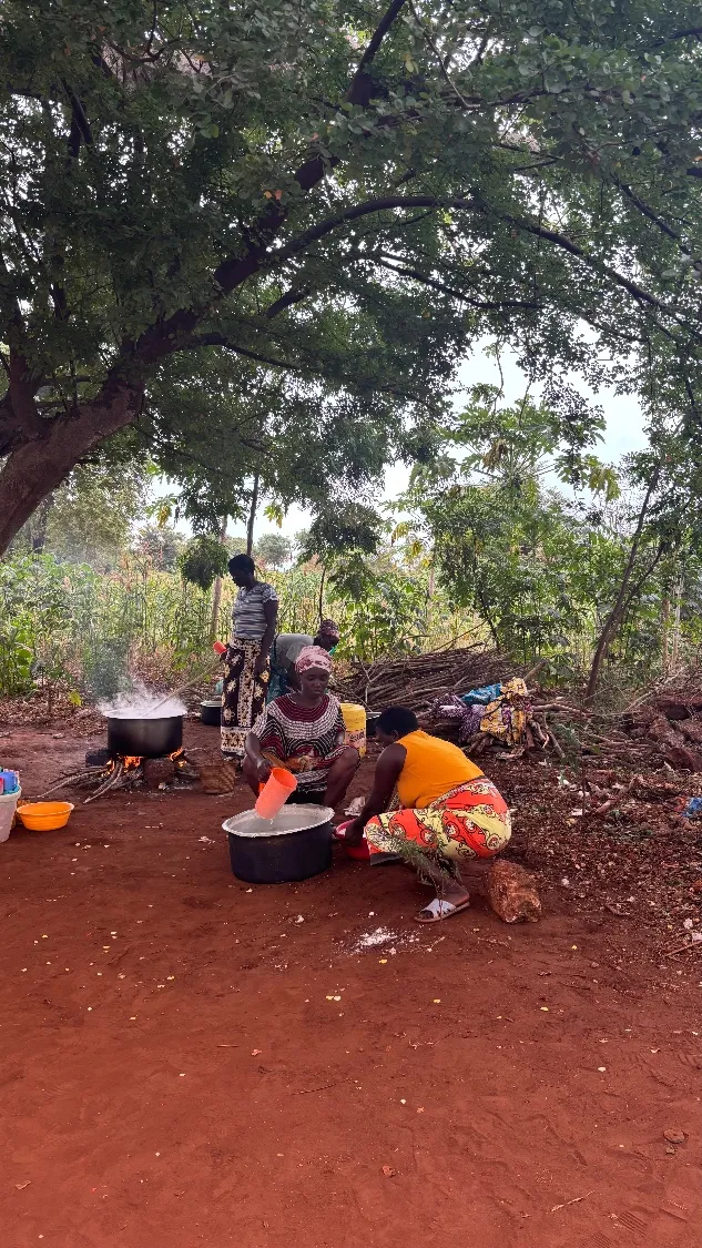 Women cook outdoors over an open fire in a rural community in Kilifi County, Kenya.
